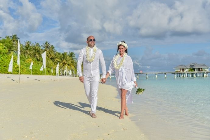 A couple standing on the beach in the Maldives