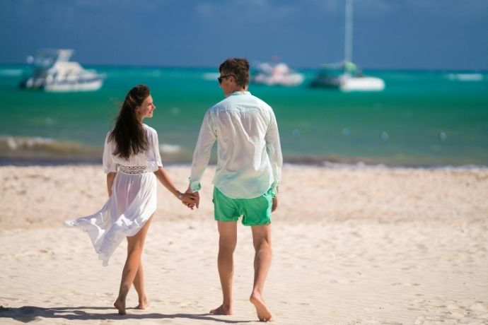 A couple walking on a beach holding hands