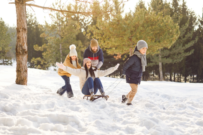 Family having fun sledding in snow for the best things to do