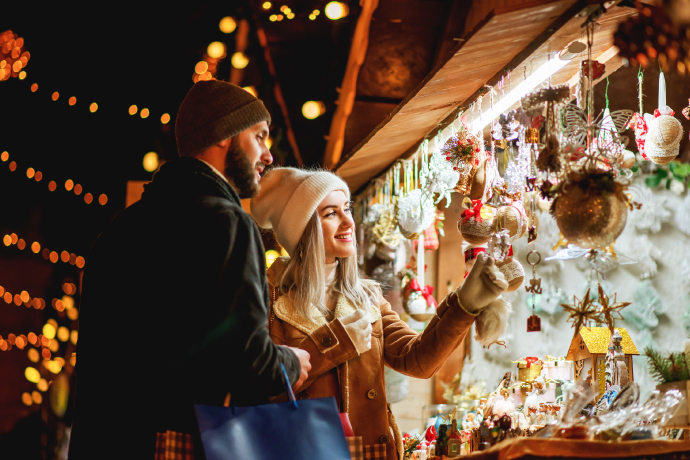 Couple shopping at a festive Christmas market for the best things to do