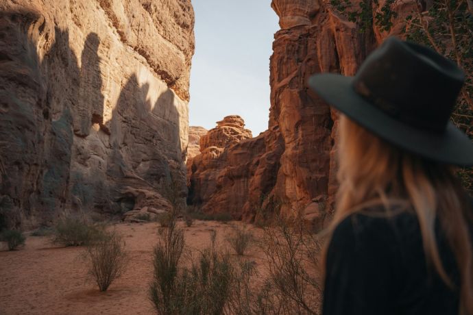 A woman is standing in a Hisma Desert canyon