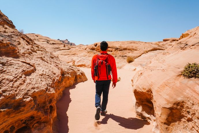 A man is walking through the Hisma Desert, Saudi Arabia