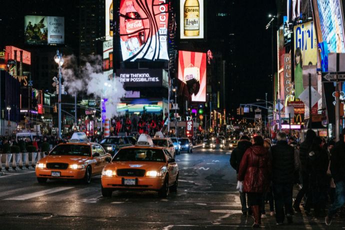 People walking on the street with cars in Times Square in New York, USA