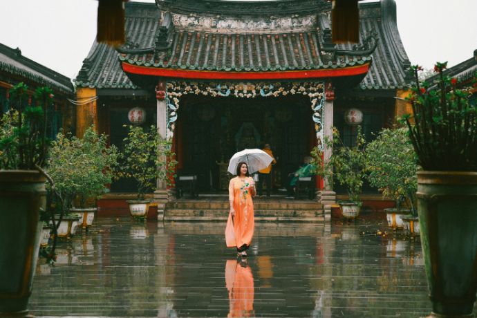 Woman with umbrella in front of traditional building